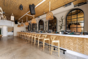 Interior of Soluna Toronto restaurant featuring the stylish bar seating area with modern coastal-inspired design, perfect for brunch and cocktails on Queen Street West.